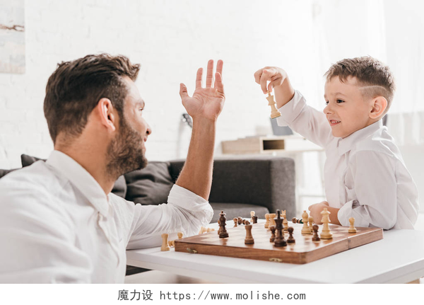 父亲和儿子在一起下象棋爸爸和儿子在家里一起下棋